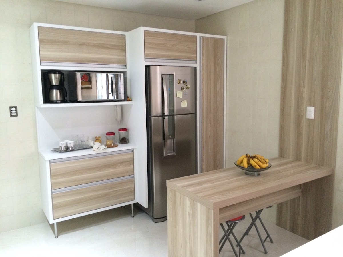 Cozinha planejada em tom de madeira com geladeira integrada